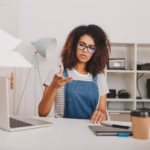 annoyed-curly-girl-glasses-striped-shirt-scatter-documents-sitting-table-looking-away-unhappy-young-woman-working-with-laptop-laptop-doing-her-job-office_197531-25340