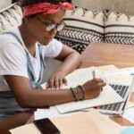 sideways-shot-black-busy-female-journalist-studies-papers-writing-article_273609-43858